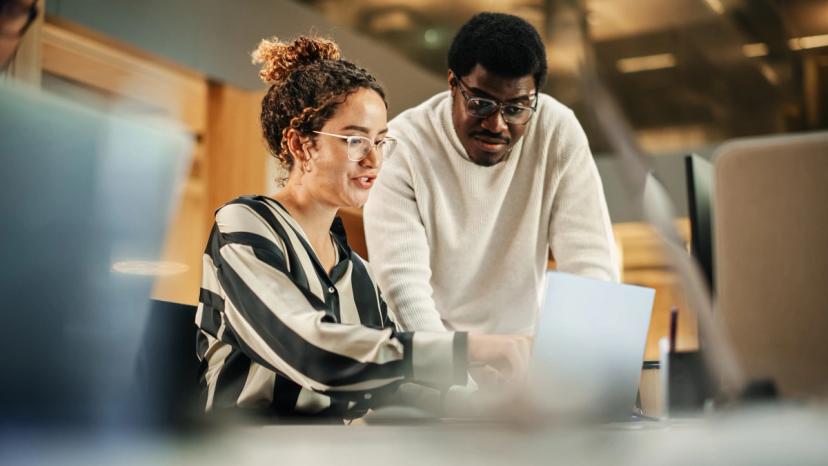 Two people looking at something on a laptop